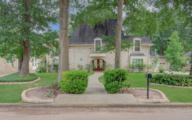 10523 Fawnview Dr, Houston, TX 77070 - french provincial home with french doors, a front lawn, brick siding, and roof with shingles