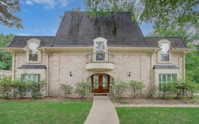 10523 Fawnview Dr, Houston, TX 77070 - french country style house featuring french doors, a balcony, a front yard, roof with shingles, and brick siding