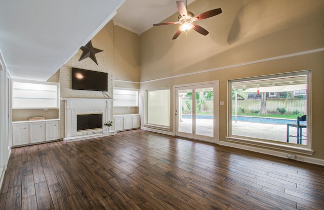 10523 Fawnview Dr, Houston, TX 77070 - unfurnished living room featuring high vaulted ceiling, ceiling fan, crown molding, a brick fireplace, and dark wood-style flooring