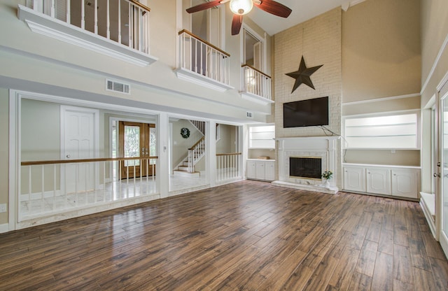 10523 Fawnview Dr, Houston, TX 77070 - unfurnished living room featuring a high ceiling, ceiling fan, a fireplace, wood finished floors, and plenty of natural light
