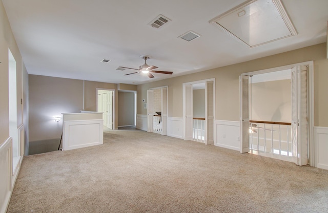 10523 Fawnview Dr, Houston, TX 77070 - empty room with attic access, light colored carpet, a wainscoted wall, a ceiling fan, and a decorative wall