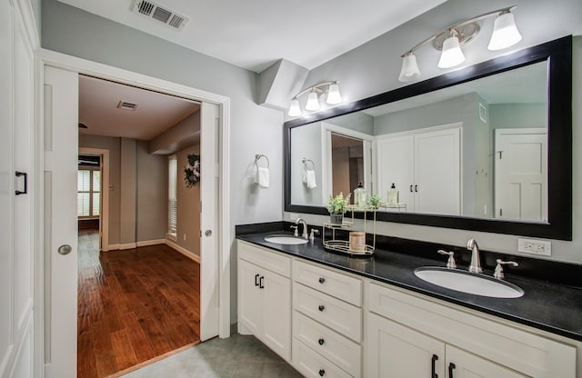 10523 Fawnview Dr, Houston, TX 77070 - full bathroom featuring double vanity, wood finished floors, and baseboards