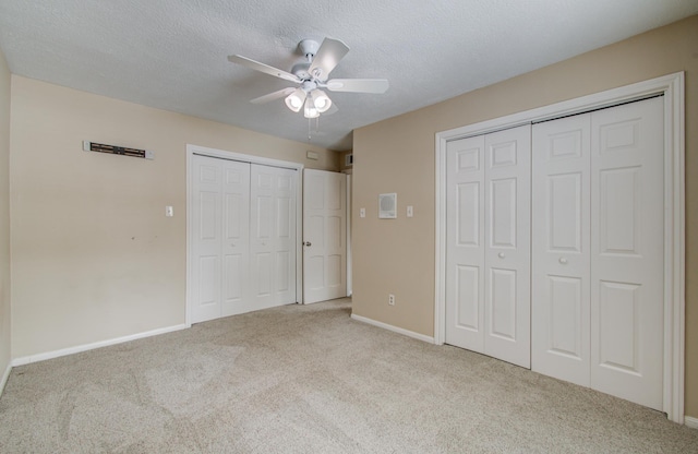 10523 Fawnview Dr, Houston, TX 77070 - unfurnished bedroom featuring carpet flooring, multiple closets, baseboards, a textured ceiling, and a ceiling fan