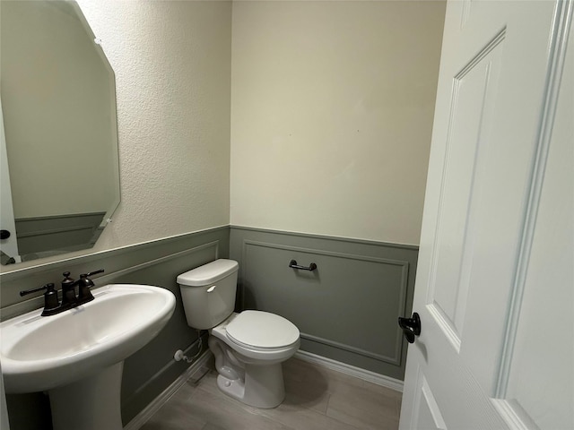 10307 Harmon Smith Dr, Houston, TX 77025 - half bath featuring toilet and a wainscoted wall