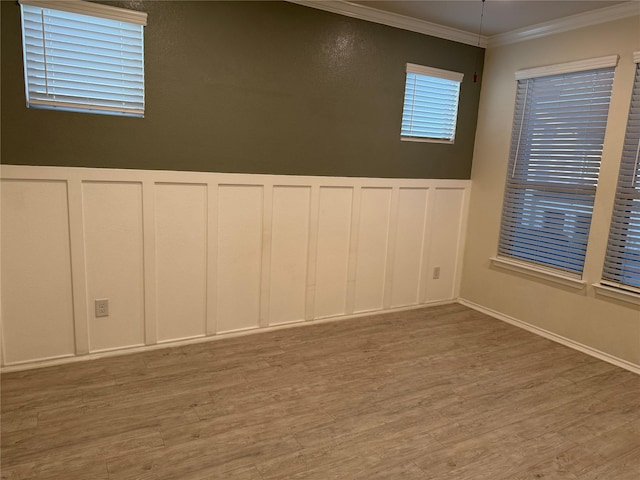 10307 Harmon Smith Dr, Houston, TX 77025 - spare room featuring a decorative wall, light wood-type flooring, ornamental molding, and a wainscoted wall