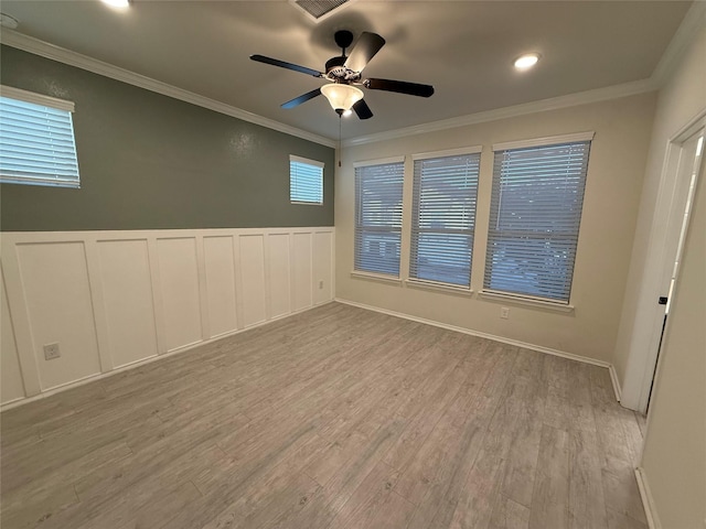 10307 Harmon Smith Dr, Houston, TX 77025 - unfurnished room with light wood-style floors, ceiling fan, wainscoting, ornamental molding, and a decorative wall