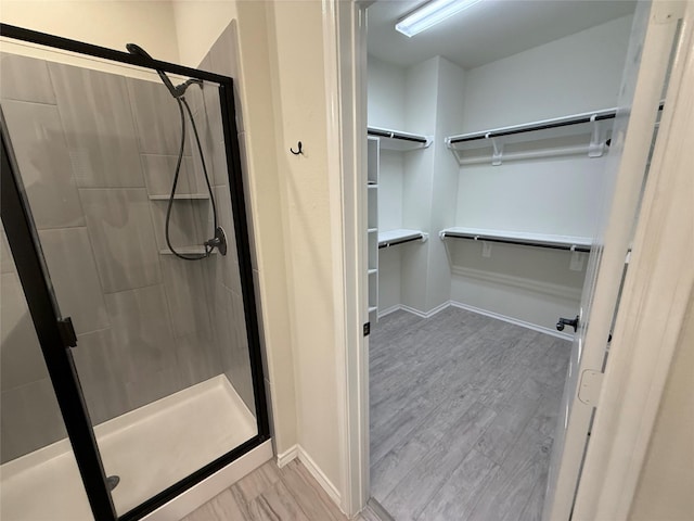 10307 Harmon Smith Dr, Houston, TX 77025 - full bath with a walk in closet, a stall shower, and wood finished floors
