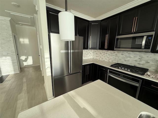 10307 Harmon Smith Dr, Houston, TX 77025 - kitchen featuring stainless steel appliances, dark cabinetry, crown molding, backsplash, and wood finished floors