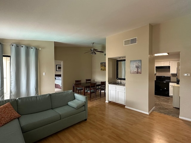 8100 Cambridge St Unit 30, Houston, TX 77054 - living area featuring wood finished floors, a ceiling fan, and baseboards