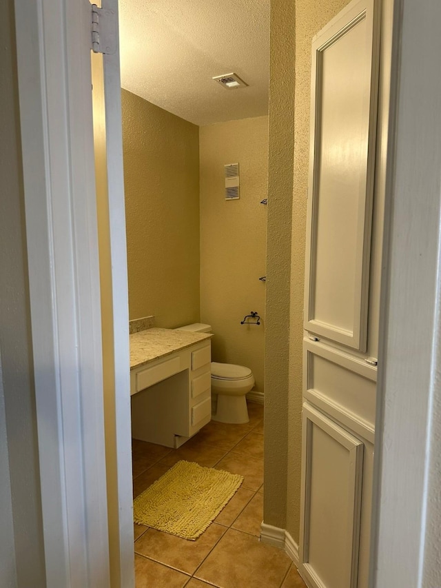 8100 Cambridge St Unit 30, Houston, TX 77054 - bathroom featuring a textured wall, tile patterned flooring, toilet, a textured ceiling, and vanity