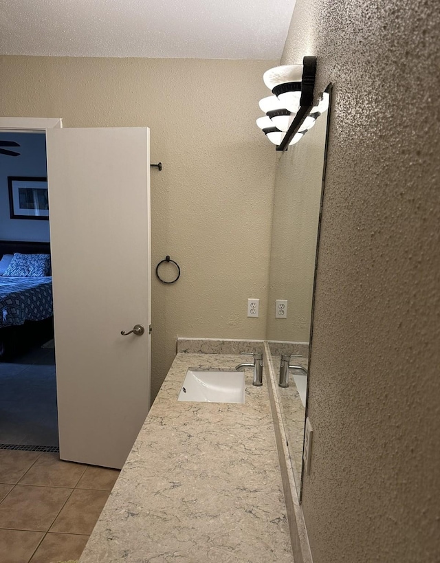 8100 Cambridge St Unit 30, Houston, TX 77054 - bathroom with tile patterned floors, a textured wall, double vanity, and ensuite bath