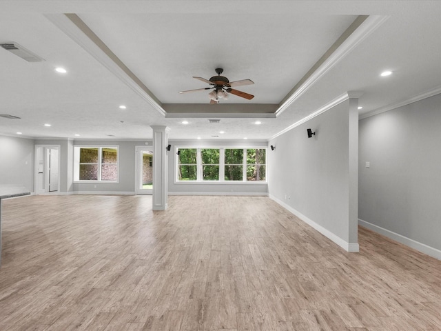 5401 Palm Dr, Dickinson, TX 77539 - unfurnished living room featuring healthy amount of natural light, ceiling fan, a tray ceiling, decorative columns, and ornamental molding