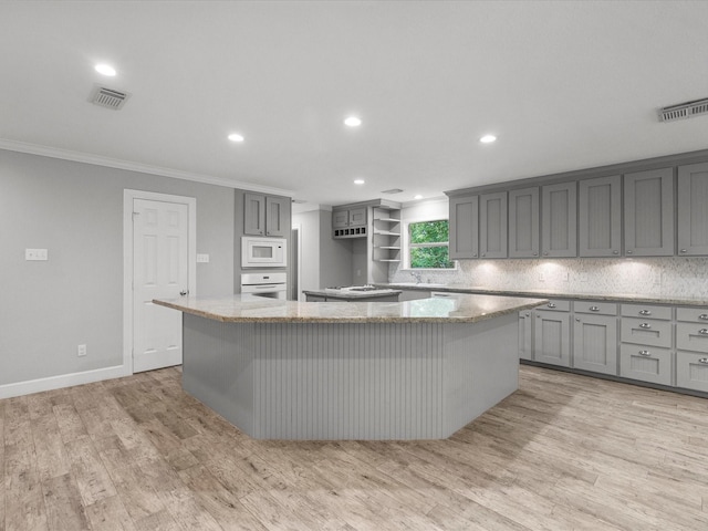 5401 Palm Dr, Dickinson, TX 77539 - kitchen with white appliances, a center island, crown molding, gray cabinets, and light wood-style flooring