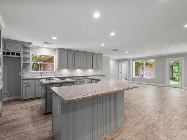 5401 Palm Dr, Dickinson, TX 77539 - kitchen featuring gray cabinets, a center island, decorative backsplash, recessed lighting, and wood finished floors
