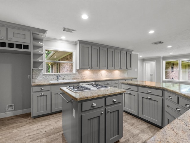 5401 Palm Dr, Dickinson, TX 77539 - kitchen with gray cabinetry, a sink, white gas cooktop, crown molding, and backsplash