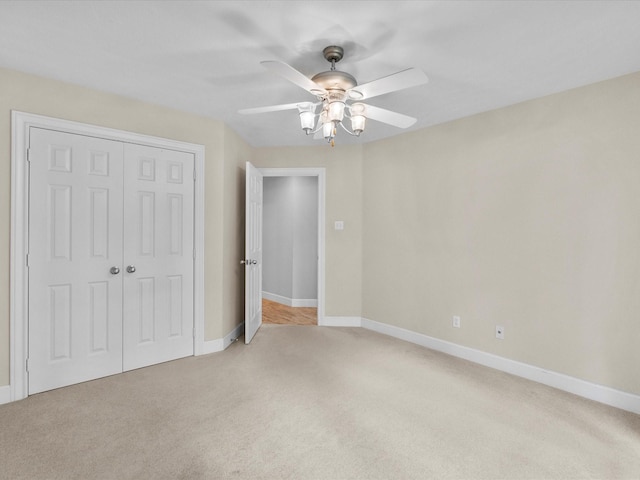 5401 Palm Dr, Dickinson, TX 77539 - unfurnished bedroom with light colored carpet, a closet, baseboards, and ceiling fan
