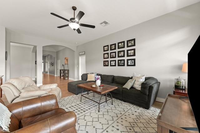 31815 Forest Oak Ln, Conroe, TX 77385 - living room featuring arched walkways, a ceiling fan, light wood-style flooring, and baseboards