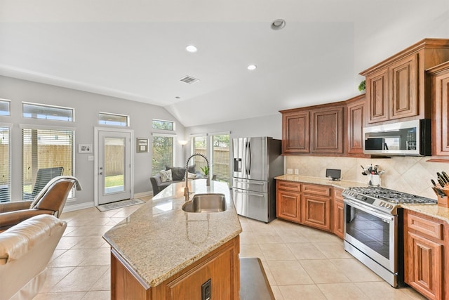 31815 Forest Oak Ln, Conroe, TX 77385 - kitchen featuring appliances with stainless steel finishes, open floor plan, a sink, lofted ceiling, and tasteful backsplash