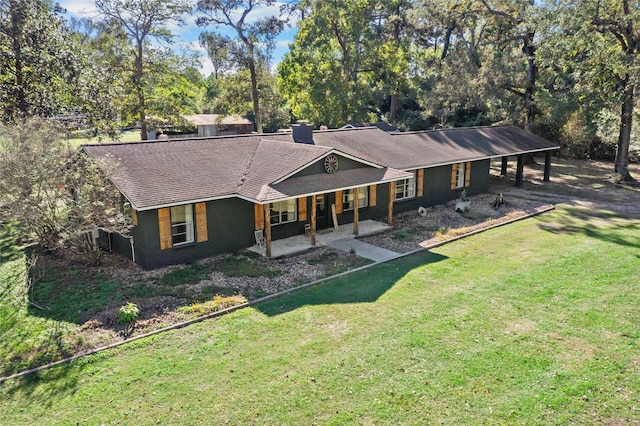 14232 Calhoun Rd, Conroe, TX 77302 - rear view of property featuring a porch, a yard, a chimney, view of scattered trees, and a carport