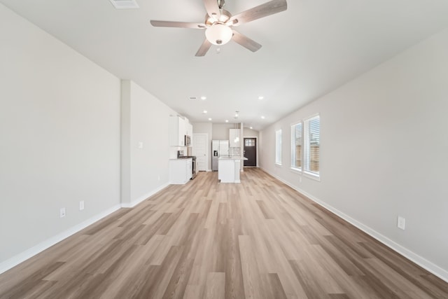 18733 Bliss Pl, New Caney, TX 77357 - unfurnished living room with light wood-style floors, baseboards, ceiling fan, and recessed lighting