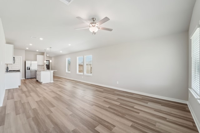 18733 Bliss Pl, New Caney, TX 77357 - unfurnished living room with baseboards, healthy amount of natural light, light wood-style floors, recessed lighting, and a ceiling fan