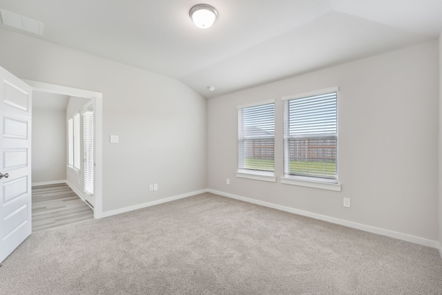 18733 Bliss Pl, New Caney, TX 77357 - empty room with light carpet, lofted ceiling, and baseboards
