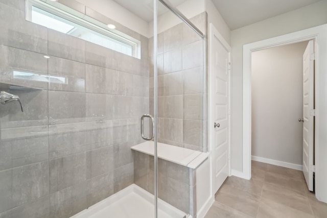 18733 Bliss Pl, New Caney, TX 77357 - bathroom featuring a stall shower, tile patterned floors, and baseboards