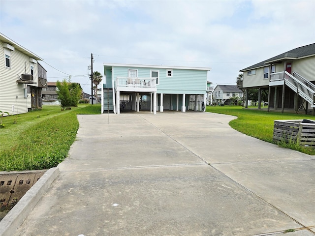 16611 Jolly Roger Rd, Jamaica Beach, TX 77554 - beach home with stairway, a front yard, concrete driveway, and a carport