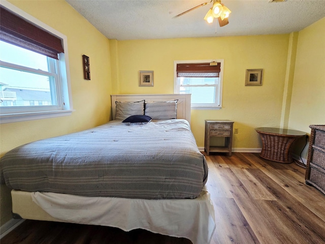16611 Jolly Roger Rd, Jamaica Beach, TX 77554 - bedroom featuring wood finished floors, a textured ceiling, a ceiling fan, and baseboards
