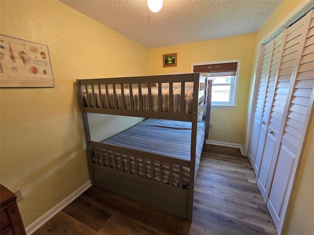 16611 Jolly Roger Rd, Jamaica Beach, TX 77554 - bedroom featuring wood finished floors, a textured ceiling, baseboards, a textured wall, and a closet