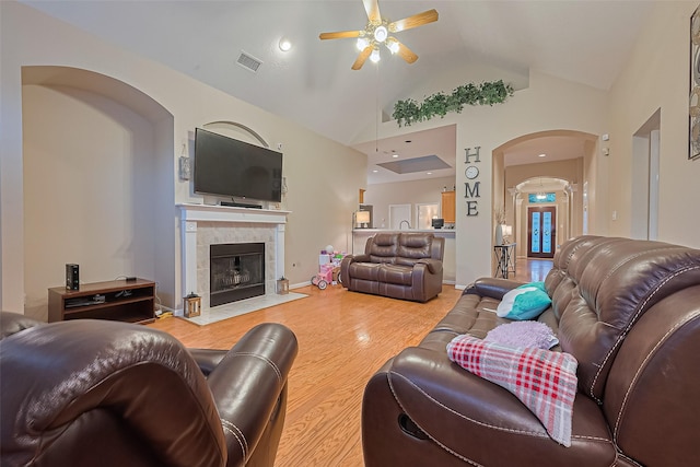 2403 Crescent Hollow Ct, Spring, TX 77388 - living area featuring arched walkways, a ceiling fan, wood finished floors, a tile fireplace, and high vaulted ceiling