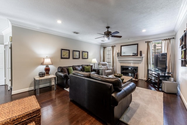 17718 Dove Tree Ln, Spring, TX 77379 - living area featuring a glass covered fireplace, ornamental molding, ceiling fan, a textured ceiling, and dark wood finished floors