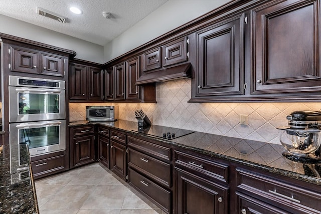 17718 Dove Tree Ln, Spring, TX 77379 - kitchen with appliances with stainless steel finishes, extractor fan, a textured ceiling, dark stone countertops, and tasteful backsplash