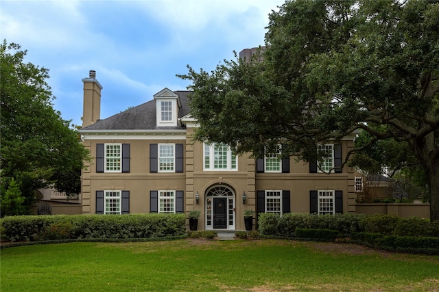 5567 Longmont Dr, Houston, TX 77056 - colonial inspired home featuring a chimney, a front lawn, and stucco siding