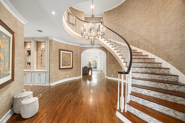 5567 Longmont Dr, Houston, TX 77056 - foyer featuring arched walkways, ornamental molding, baseboards, wood finished floors, and a towering ceiling