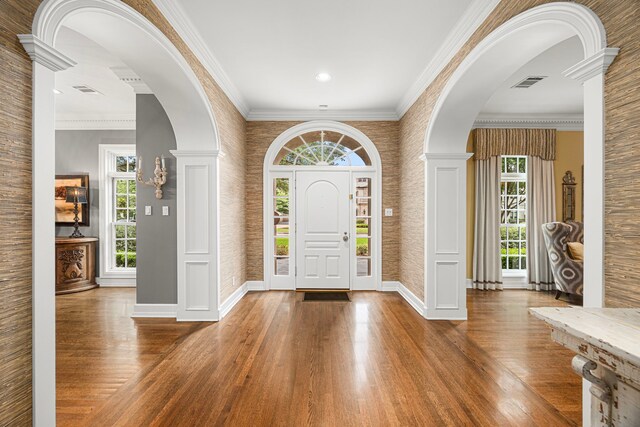 5567 Longmont Dr, Houston, TX 77056 - foyer entrance featuring wood finished floors, baseboards, arched walkways, and crown molding
