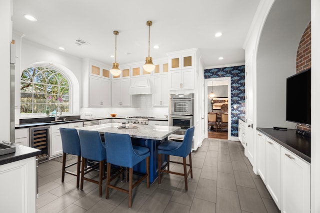 5567 Longmont Dr, Houston, TX 77056 - kitchen with wine cooler, crown molding, custom range hood, a sink, and stainless steel double oven