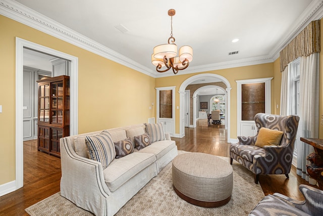 5567 Longmont Dr, Houston, TX 77056 - living area featuring arched walkways, a chandelier, wood finished floors, crown molding, and decorative columns