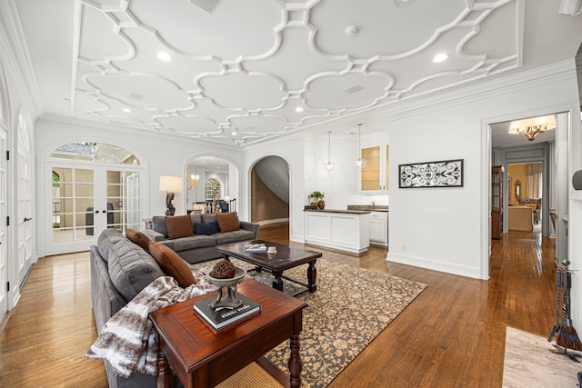 5567 Longmont Dr, Houston, TX 77056 - living room with arched walkways, light wood-style floors, ornamental molding, french doors, and recessed lighting