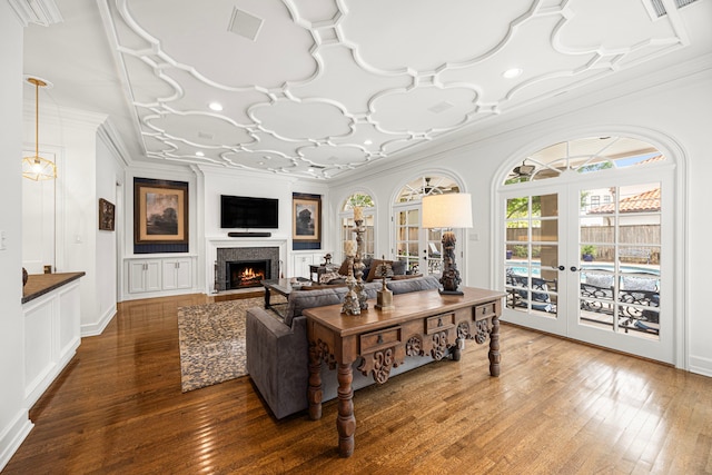 5567 Longmont Dr, Houston, TX 77056 - living area featuring a lit fireplace, wood-type flooring, ornamental molding, and french doors