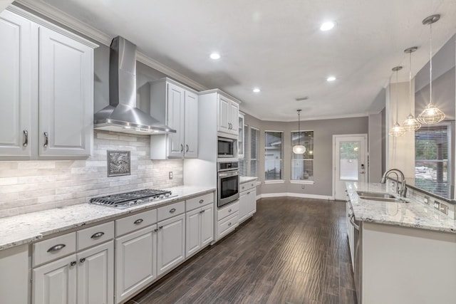 4531 Mulberry Park Ln, Houston, TX 77345 - kitchen featuring appliances with stainless steel finishes, wall chimney range hood, a sink, crown molding, and baseboards