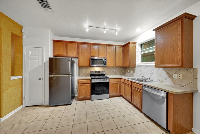 10239 W Palm Lake Dr, Houston, TX 77034 - kitchen featuring appliances with stainless steel finishes, a sink, light tile patterned floors, backsplash, and light countertops
