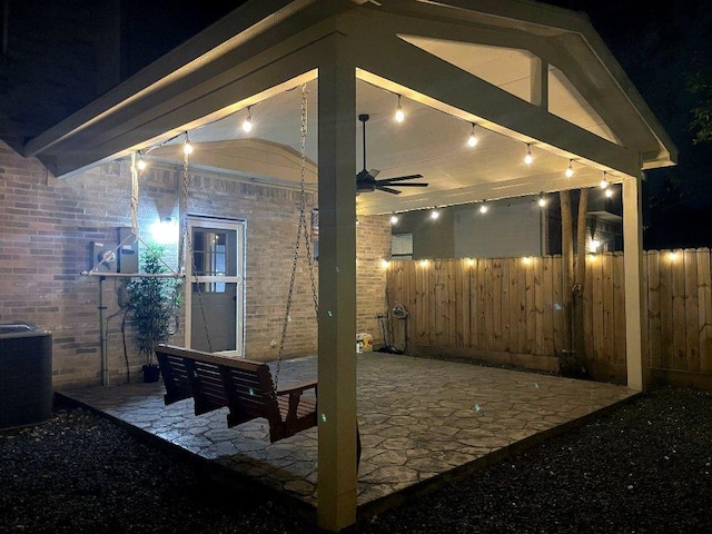 10239 W Palm Lake Dr, Houston, TX 77034 - patio at night with a ceiling fan, fence, and cooling unit