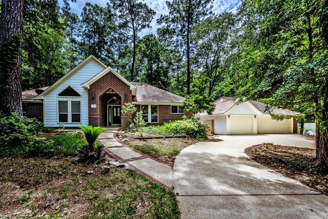 1967 Greentree Dr, Huntsville, TX 77340 - view of front of property with brick siding, a garage, an outdoor structure, and concrete driveway