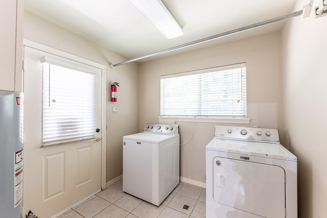 1967 Greentree Dr, Huntsville, TX 77340 - washroom with washing machine and dryer, water heater, light tile patterned flooring, and baseboards