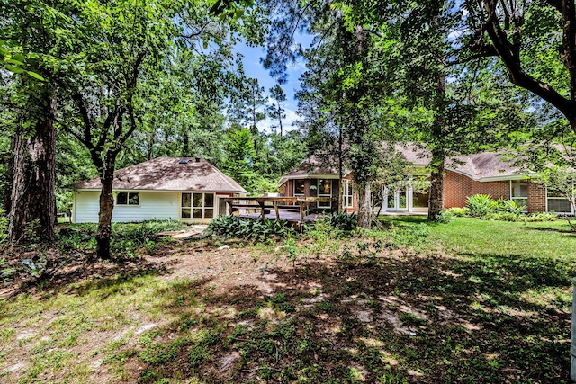 1967 Greentree Dr, Huntsville, TX 77340 - back of property featuring a wooden deck and a yard