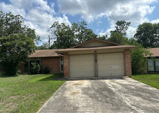 4735 El Vedado St, San Antonio, TX 78233 - ranch-style home featuring a garage, driveway, brick siding, and a front lawn