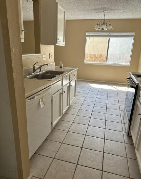 4735 El Vedado St, San Antonio, TX 78233 - kitchen with dishwasher, a sink, a textured ceiling, electric range oven, and light tile patterned flooring