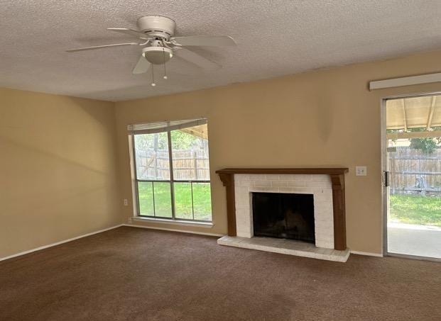 4735 El Vedado St, San Antonio, TX 78233 - unfurnished living room with a textured ceiling, ceiling fan, a brick fireplace, carpet flooring, and baseboards