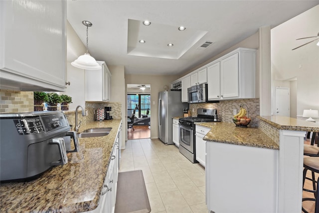 16310 Leamington Ln, Houston, TX 77095 - kitchen with stainless steel appliances, a ceiling fan, a sink, a peninsula, and a breakfast bar